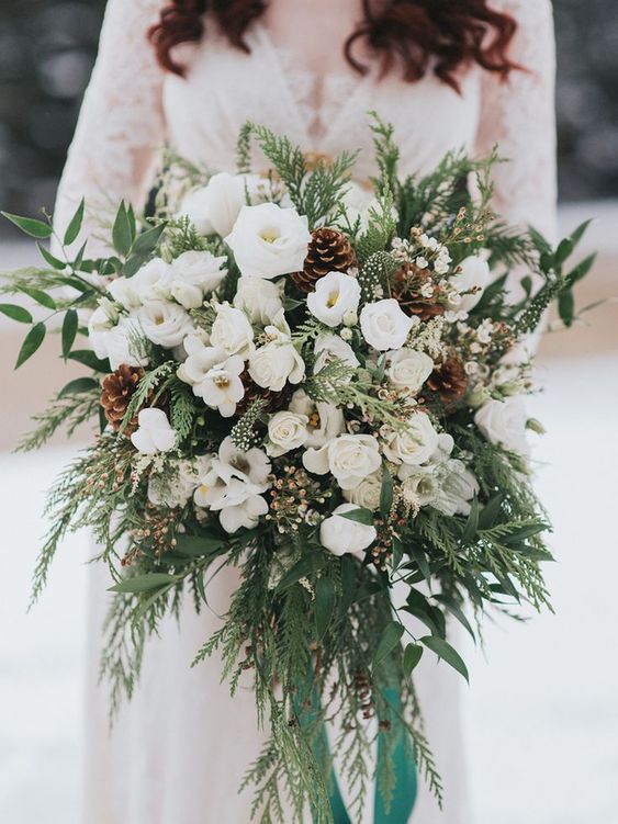 Proof that Winter is the Perfect Time for a Romantic Outdoor Wedding! Check out this gorgeous winter wedding bouquet and flowers. Wedding bouquets is a must to have no matter what time of year you are tying the knot. For winter brides who wants reflect your wedding season, you can add some type of winter green, berries , icy touches, silver ribbons, fluffy pieces and pine cones. 