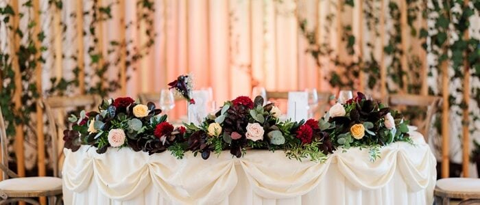 Deciding between a sweetheart table and a head table? Here's what to consider! A sweetheart table offers a romantic, intimate setting for the newlyweds, perfect for enjoying personal moments during the celebration. Adorn it with lush florals and elegant candles for a dreamy vibe. On the other hand, a head table is ideal for those who want to celebrate with their bridal party, fostering a communal and inclusive atmosphere. It’s perfect for large gatherings and creating a sense of togetherness. Whether you choose a sweetheart or head table, both options can beautifully complement your wedding theme. Wedding table ideas, wedding reception seating, romantic wedding decor, bridal party table.